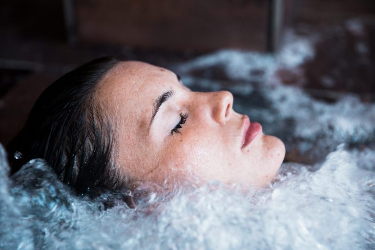 Ledová koupel cold plunge doma: jak začít, jaké benefity přináší a kdy přestat Ledová koupel cold plunge — žena v ledové vodě